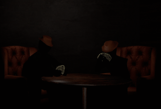 Bruce and Sal sitting across the table during a game of Shuddap